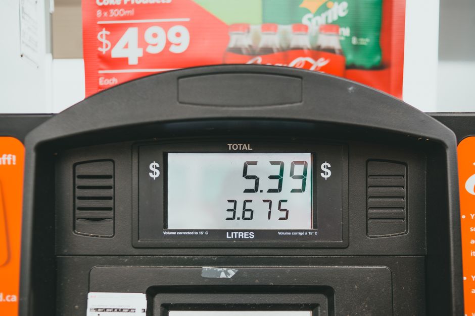 Close-up image of a fuel pump display showing a total cost of $5.39 for 3.675 litres of petrol, with a focus on the digital screen and surrounding black fuel dispensing mechanism. The background inclu